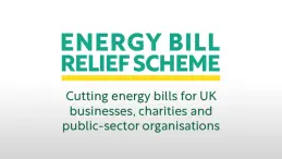 A person holding an energy bill with a Warm Home Discount notice