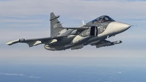 Swedish Gripen jet flying over a landscape